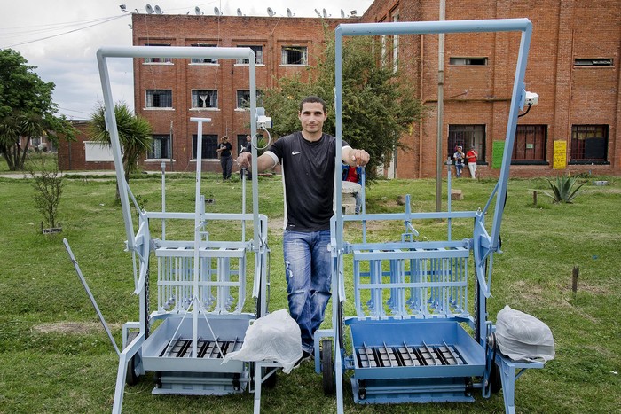 Aníbal Peña con las máquinas de hacer bloques y ladrillos construídas en la herrería. · Foto: Alessandro Maradei