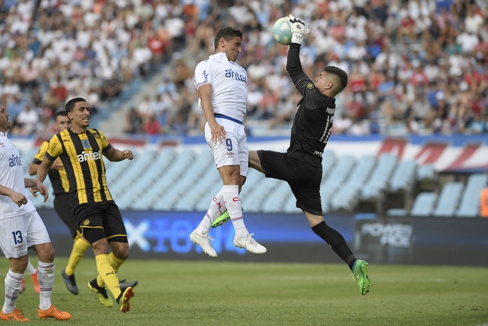 Gonzalo Bergessio, de Nacional, y Kevin Dawson, arquero de Peñarol, durante el clásico del Torneo Clausura en el estadio Centenario. Foto: Sandro Pereyra