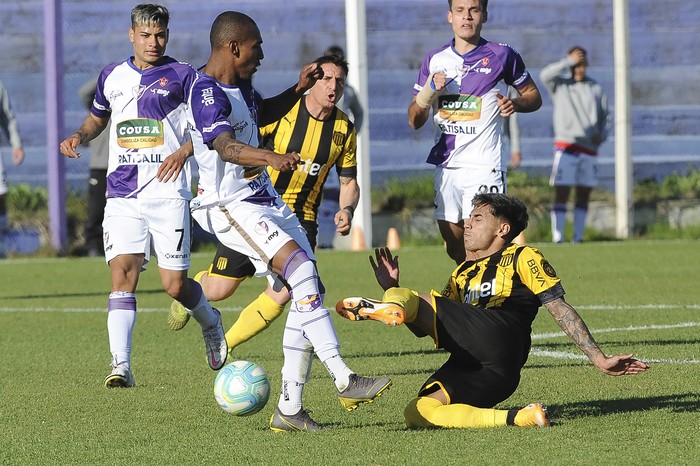 Ángel Rodríguez, Kevin Alaniz y Manuel Ugarte de Fénix, y Cristian Rodríguez y Facundo Torres, de Peñarol, en el Parque Capurro, por la 15a fecha del Torneo Apertura. · Foto: Federico Gutiérrez