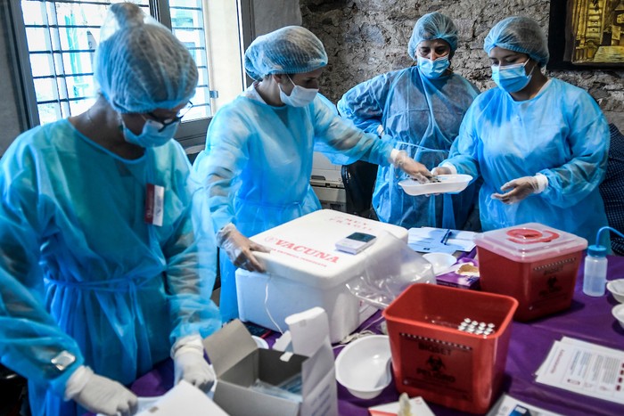 Enfermeros del Hospital de Clinicas durante la jornada de vacunación contra el coronavirus SARS-CoV-2 con las vacunas de Pfizer, en la sede de la Federación de Funcionarios de la Salud en Montevideo. · Foto: Javier Calvelo, adhocFOTOS