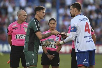 Los capitanes Mauro Goicoechea, golero de Danubio, y Sebastián Coates, de Nacional, intercambian libros de Eduardo Galeano previo al inicio del partido. · Foto: Guillermo Legaria, Agencia Gamba