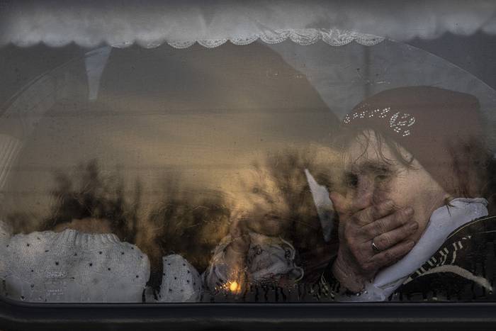 Una mujer con un bebé en un autobús que llega a un punto de evacuación en Zaporizhzhia, Ucrania, junto a otras personas que huyen de la ciudad sitiada por militares rusos en el sureste de Mariupol y la ocupada Melitopol. · Foto: Roman Pilipey, EFE