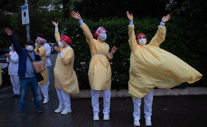 Trabajadores del sanatorio Heathcare saludan los aplausos de los vecinos ayer, en Barcelona. · Foto: Josep Lago, AFP