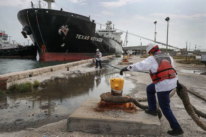 Trabajadores portuarios ayudan a atracar al petrolero Texas Voyager, este martes, en Port Everglades, Florida.
 · Foto: Joe Raedle, Getty Images, Afp