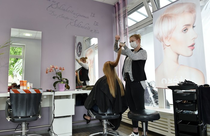 La peluquera Sarah Stemmer trabaja en su salón en Puchheim, cerca de Munich, Alemania.
 · Foto: Christof Stache, AFP