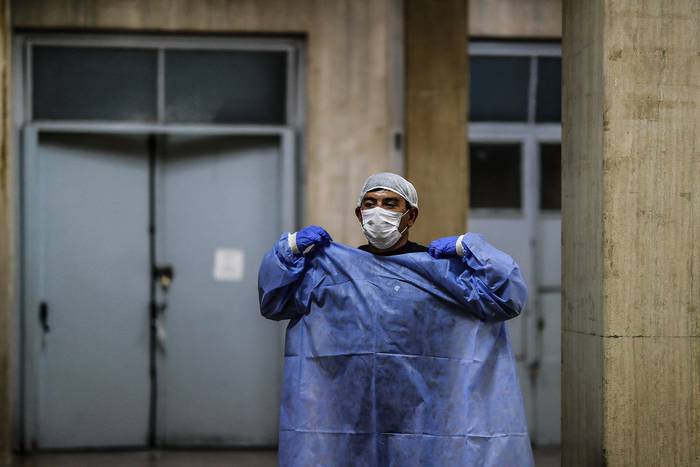 Enfermero del Hospital Posadas se cambia luego de realizar un traslado de paciente con coronavirus, el 12 de junio en Buenos Aires. · Foto: Juan Ignacio Roncoroni, EFE 