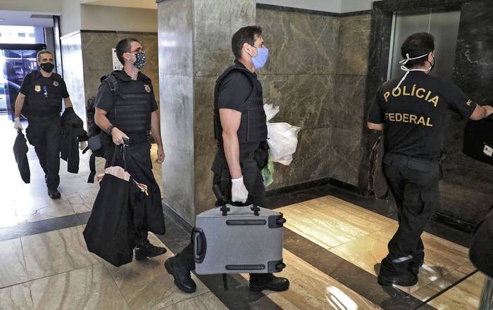 Agentes de la policía federal llevan pruebas incautadas en la residencia oficial del gobernador de Río de Janeiro Wilson Witzel.
 · Foto: Fabio Motta, AFP