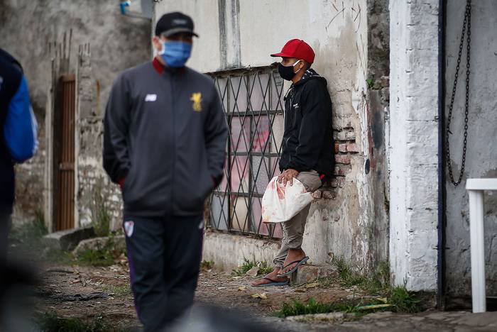 Vecinos esperan para recibir alimentos en una olla popular realizada por organizaciones sociales en el barrio Villa Fiorito, en Buenos Aires. · Foto: Juan Ignacio Roncoroni, EFE 