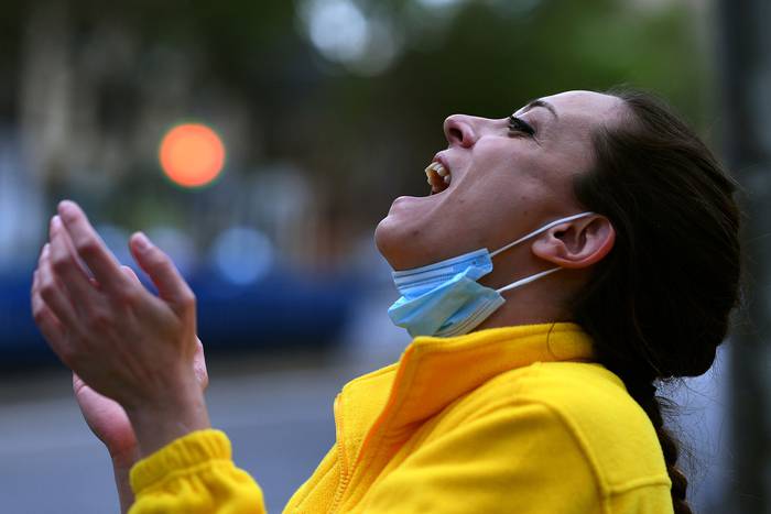 Una enfermera saluda mientras ella y sus colegas son aplaudidos, el lunes, frente al Hospital Gregorio Marañón, en Madrid.
 · Foto: Gabriel Bouys, AFP