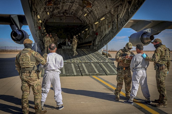 Funcionarios federales abordando a migrantes detenidos en un vuelo a la Base Naval de la Bahía de Guantánamo, desde un lugar no revelado, 4 de febrero, en Estados Unidos. · Foto: Departamento de Seguridad de Estados Unidos, AFP