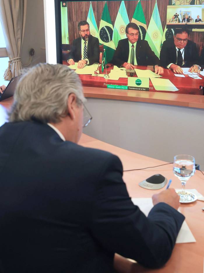 Alberto Fernández (i) y Jair Bolsonaro (centro, en la pantalla), ayer, durante una teleconferencia.  · Foto: Presidencia argentina, EFE