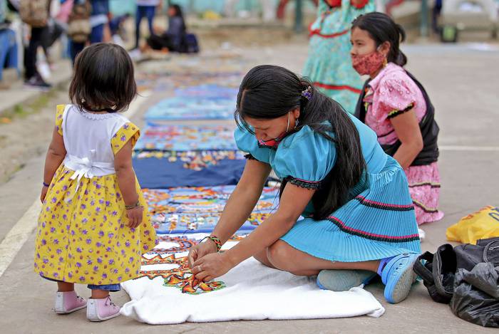 Las mujeres indígenas Embera exhiben sus artesanías para la venta callejera, el 12 de julio, en Bogotá, Colombia.
 · Foto: Daniel Muñoz, AFP
