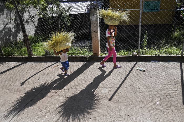 Niños con sombreros artesanales en una calle en Tlapa de Comonfort, estado de Guerrero, México, el 7 de septiembre. · Foto: Pedro Pardo, AFP