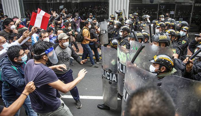 Simpatizantes del derrocado presidente peruano Martín Vizcarra, se enfrentan a policías, ayer, en Lima. · Foto: Ernesto Benavides, AFP
