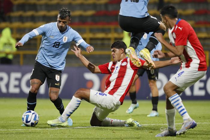 Luciano Rodríguez (i) de Uruguay y Thiago Servin (c) de Paraguay, en el Campeonato Sudamericano sub 20, en Bogotá, Colombia (09.02.2023). · Foto: Carlos Ortega, EFE
