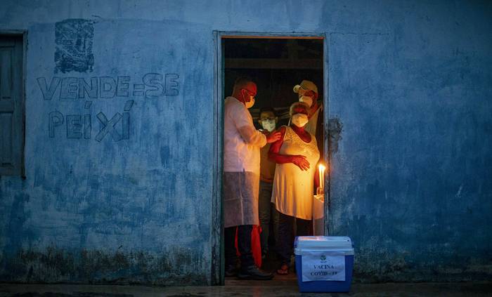La profesional de la salud Raimunda Nonata, de 70 años, recibe la vacuna CoronaVac, en su casa en la comunidad Quilombo Marajupena, ciudad de Cachoeira do Piria, estado de Pará, Brasil, el 19 de enero.
 · Foto: Tarso Sarraf, AFP