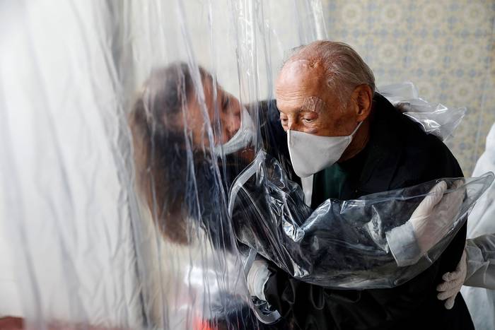 María Paula Moraes abraza, este jueves, a su padre Wanderley de 82 años, a través de una "cortina de abrazos" en una residencia de ancianos en la ciudad de San Pablo. · Foto: Sebastião Moreira, Efe
