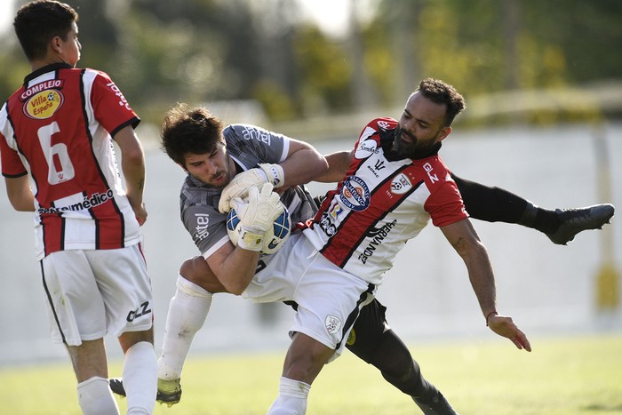 Diego Manuel Soria, golero de Canelones del Este y Luis Alfredo Leguisamo (d), de Salto, ayer, en el Estadio del Club Progreso, en Estación Atlántida, Canelones.  · Foto: Fernando Morán