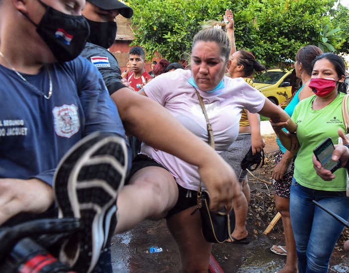 Familiares de reclusos chocan con policías fuera de la cárcel de Tacumbu, el 16 de febrero, en Asunción. · Foto: Norberto Duarte, AFP