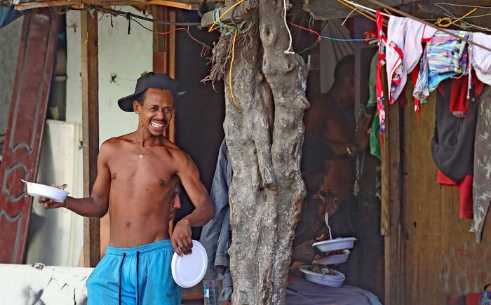 Un hombre recibe alimentos, ayer, en la favela de Maré, en Rio de Janeiro.
 · Foto: Fabio Motta, EFE