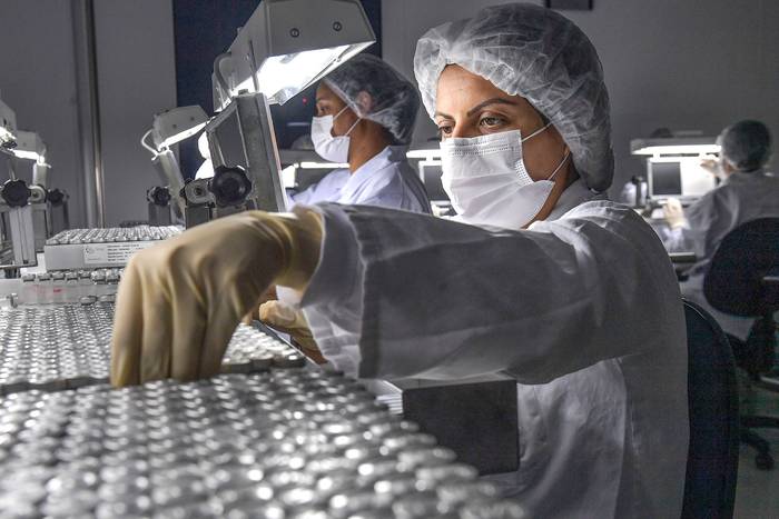 Empleados trabajan en la línea de producción de CoronaVac, la vacuna de Sinovac Biotech contra el coronavirus, este jueves, en el centro de producción biomédica de Butantan, en San, Pablo, Brasil. · Foto: Nelson Almeida, AFP