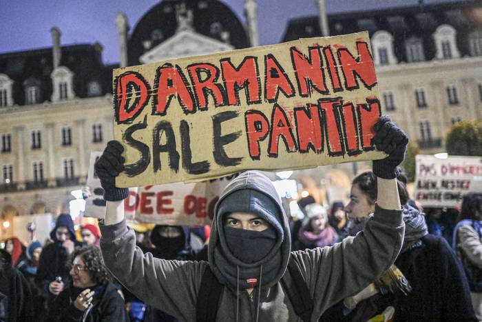 Un manifestante sostiene un cartel que dice "títere sucio de Darmanin" ,durante una manifestación contra la nueva ley de inmigración,  el 20 de diciembre de 2023, en Rennes, Francia,. · Foto: Sebastien Salom, AFP
