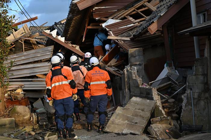 Los bomberos inspeccionan casas de madera derrumbadas en Wajima, prefectura de Ishikawa, el 2 de enero de 2024, un día después del terremoto de magnitud 7,5. · Foto: Kazuhiro Nogi, AFP 
