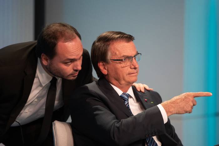 Jair Bolsonaro (d), señala junto a su hijo Carlos durante un debate, con los demás candidatos, en los estudios de TV Globo en Río de Janeiro (Brasil) (29.09.2022). · Foto: André Coelho, EFE