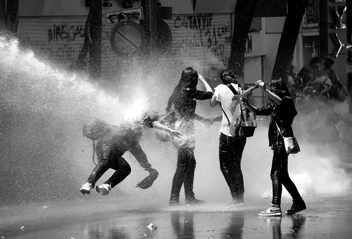 Manifestantes son alcanzados por un cañón de agua de la policía antidisturbios, ayer durante una de las revueltas que sacuden Turquía desde el viernes, en Ankara. · Foto: Muammer Tan, Efe