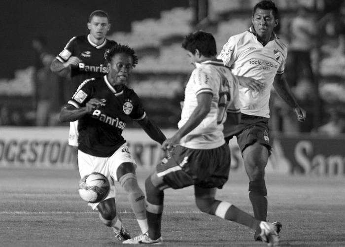 El jugador de Gremio Zé Roberto y Juan Manuel Diaz (d), de Nacional, anoche, en el Parque Central. Foto: Iván Franco, Efe