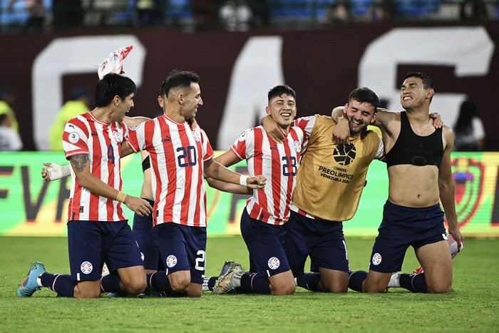 Jugadores de Paraguay celebran luego de ganarle a Venezuela y clasificar a los Juegos Olímpicos de París 2024, el 5 de febrero, en el estadio Brígido Iriarte de Caracas. · Foto: Federico Parra, AFP