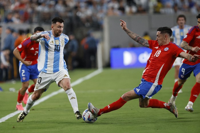 Lionel Messi, de Argentina y Rodrigo Echeverría, de Chile, en el estadio MetLife en East Rutherford, Nueva Jersey. · Foto: Eduardo Muñoz, AFP