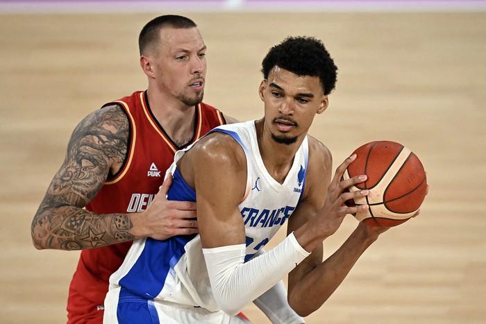 Victor Wembanyama, de Francia, y Daniel Theis, de Alemania, el 8 de agosto, en el Bercy Arena, en París. · Foto: Paul Ellis, AFP