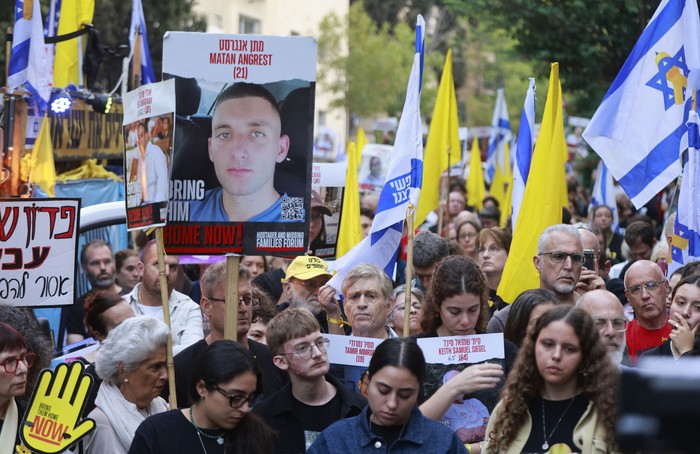 Familiares y simpatizantes de los rehenes israelíes secuestrados por Hamas en el ataque del 7 de octubre de 2023 y retenidos en Gaza, sostienen imágenes de sus seres queridos durante una protesta para pedir su liberación frente a la residencia del primer ministro, Benjamin Netanyahu, en Jerusalén, el 7 de octubre de 2024. · Foto: Menahen Kahana, AFP