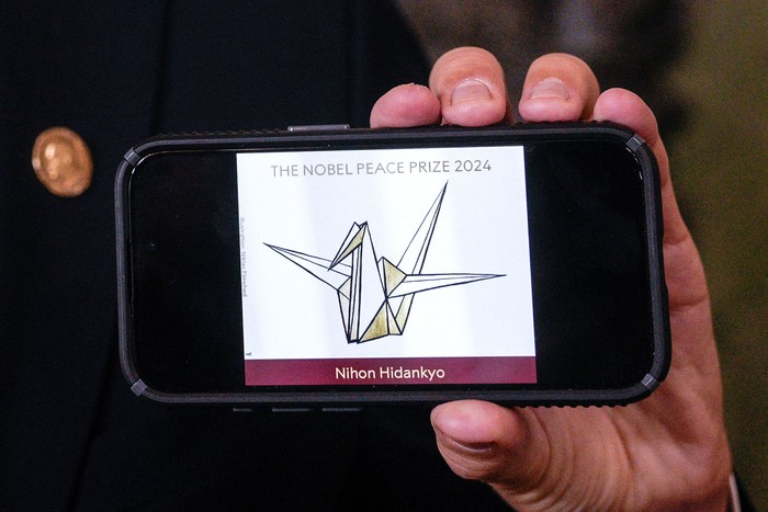 Jorgen Watne Frydnes muestra en un celular el logo de la organización japonesa Nihon Hidankyo, ganadora del Premio Nobel de la Paz 2024. · Foto: Javad Parsa, NTB, AFP