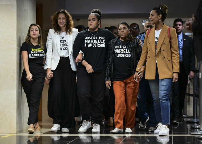 La viuda de Anderson Gomes, Ágatha Arnaus; la viuda de Marielle Franco, Mônica Benício; la hija de Marielle, Luyara Santos; la madre de Marielle, Marinete da Silva, y la hermana de Marielle, la ministra brasileña de Igualdad Racial, Anielle Franco, salen tras escuchar la sentencia durante el último día del juicio público de los asesinos de Marielle y su chofer, Anderson Gomes, en el Tribunal de Justicia de Río de Janeiro. · Foto: Pablo Porciúncula, AFP