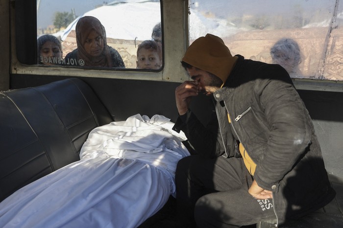 Un palestino junto al cuerpo de un familiar, muerto en un ataque israelí la noche anterior, en la parte trasera de una ambulancia fuera del hospital árabe Al Ahli, en la ciudad de Gaza. · Foto: Omar Al-Qattaa, AFP