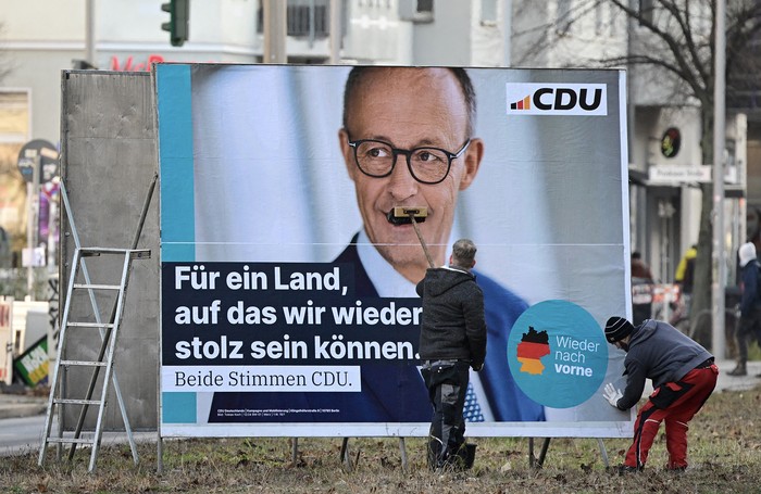 Colocación de un cartel electoral de Friedrich Merz, el 13 de enero, en Berlín. Foto: John Macdougall, AFP.