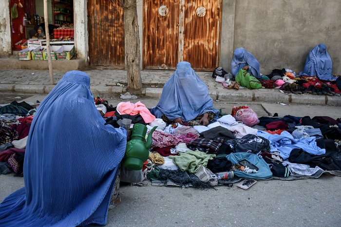 Mujeres afganas vestidas con burka venden ropa usada en una calle de Maymana, la capital de la provincia de Faryab, al noroeste de Afganistán, el 13 de enero. Foto: Atif Aryan, AFP.