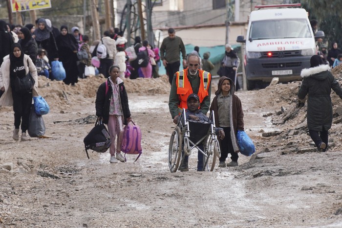 Personas que huyen del campo de refugiados de Jenín, en una calle destruida por las fuerzas israelíes en la Cisjordania ocupada. · Foto: Mohammad Mansour, AFP