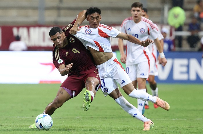 El venezolano Loureins Martínez, y el chileno Emiliano Ramos, el 23 de enero, en el estadio Metropolitano de Lara en Cabudare, estado Lara, Venezuela. · Foto: Edilzon Gamez, AFP