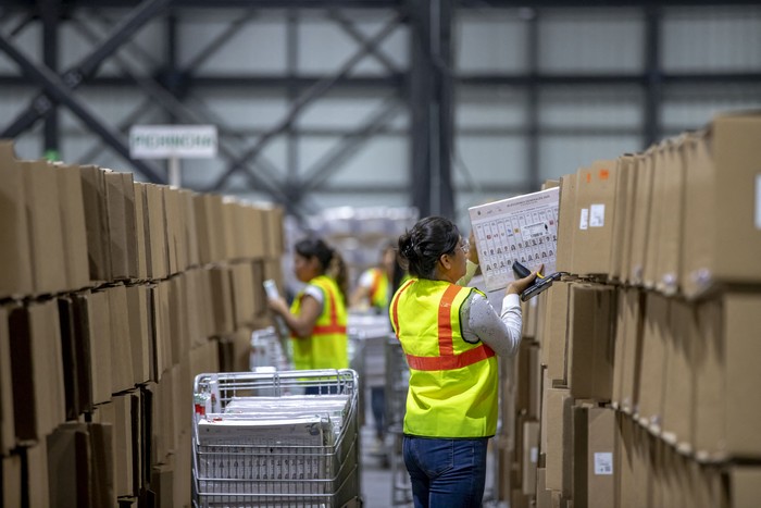 Trabajadores del Consejo Nacional Electoral de Ecuador organizan el material electoral antes de distribuirlo para las próximas elecciones presidenciales en Pifo, provincia de Pichincha, Ecuador, el 28 de enero. · Foto: Armando Prado, AFP