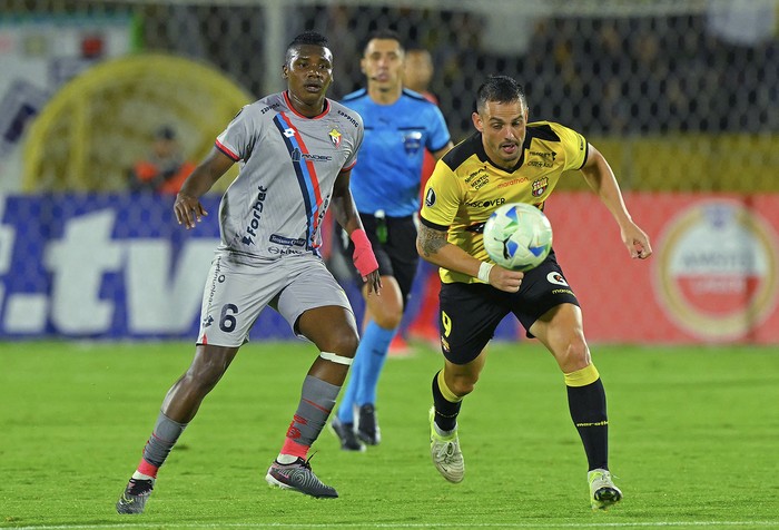 Marcos Olmedo, de El Nacional, y Octavio Rivero, de Barcelona de Ecuador, el 19 de febrero, en el estadio Olímpico Atahualpa, en Quito. Foto: Rodrigo Buendía, AFP.