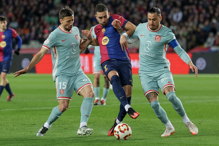 Ferrán Torres (C), de Barcelona, y Clement Lenglet y José María Giménez, de Atlético de Madrid, el 25 de febrero, en el Estadio Olímpico Lluis Campanys de Barcelona. · Foto: Lluis Gene, AFP