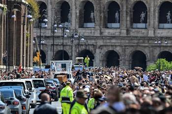 La gente a lo largo de la Via dei Fori Imperiali, en Roma, mientras el ataúd del papa Francisco es transportado desde la Basílica de San Pedro a la Basílica de Santa María Maggiore, el 26 de abril. · Foto: Damien Meyer / AFP
