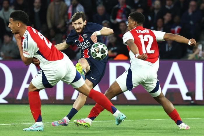 El delantero del PSG Khvicha Kvaratskhelia, junto a William Saliba y Jurrien Timber, de Arsenal, durante el partido de vuelta de semifinales de la UEFA Champions League, en París, el 7 de mayo. · Foto: Thomas Samson, AFP