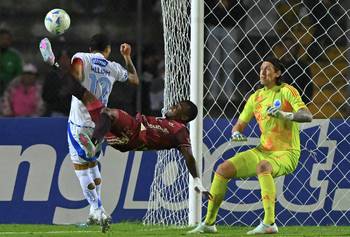Cristian Penilla (C), de Mushuc Runa, y Cassio, del Cruzeiro, el 7 de mayo, en el estadio Fernando Guerrero en Riobamba, Ecuador. · Foto: Rodrigo Buendía, AFP