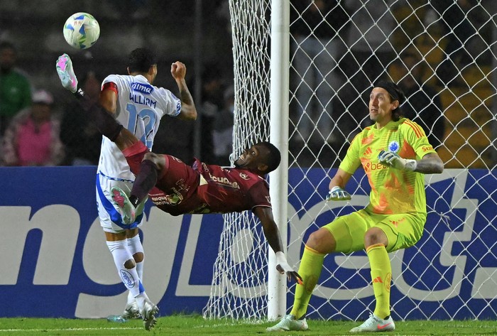 Cristian Penilla (C), de Mushuc Runa, y Cassio, del Cruzeiro, el 7 de mayo, en el estadio Fernando Guerrero en Riobamba, Ecuador. Foto: Rodrigo Bunedía, AFP.