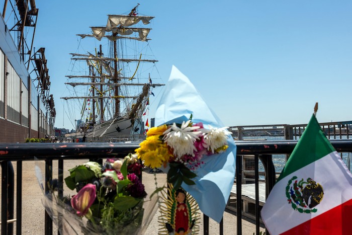 Flores y banderas frente al velero Cuauhtémoc de la Armada de México. · Foto: Spencer Platt, AFP