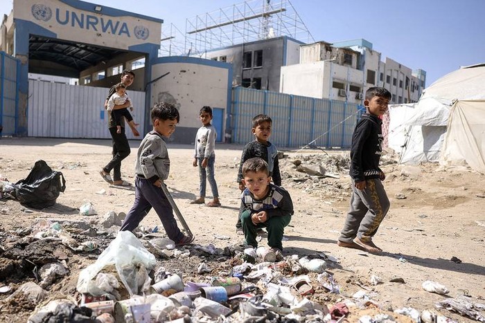 Niños frente a la sede cerrada de la agencia de la ONU para los refugiados palestinos, en la ciudad de Gaza (mayo de 2025). · Foto: Bashar Taleb, AFP